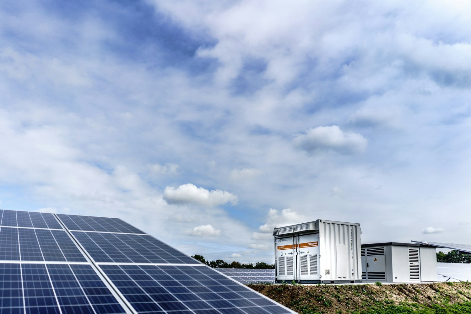 Containerised battery energy storage unit beside a solar array